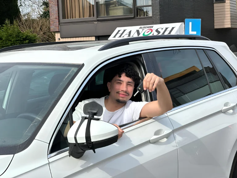 Blije leerling met autosleutel in lesauto van Rijschool Hanosh
